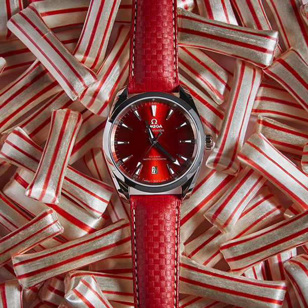 Red Omega Seamaster watch on top of peppermint mint straws 